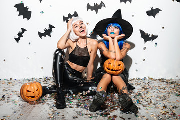 Two pretty young women in leather halloween costumes