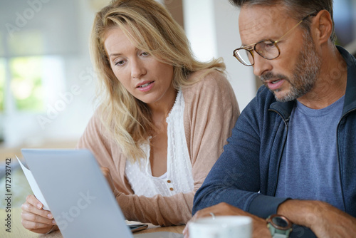 Mature couple at home working on laptop computer