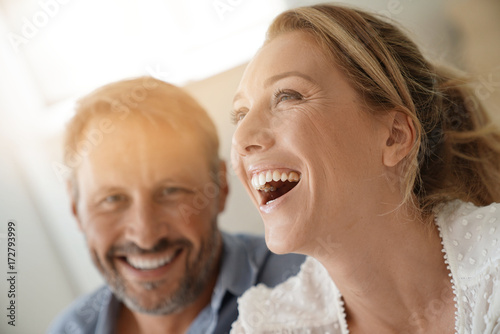 Mature couple relaxing at home, looking at camera photo