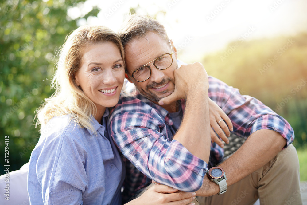 Portrait of mature couple relaxing in outdoor sofa Portrait of mature couple relaxing in outdoor sofa