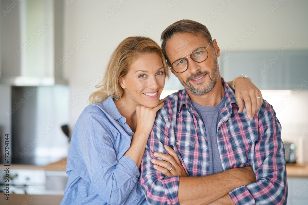 Portrait of mature couple standing in home kitchen Portrait of mature couple standing in home kitchen