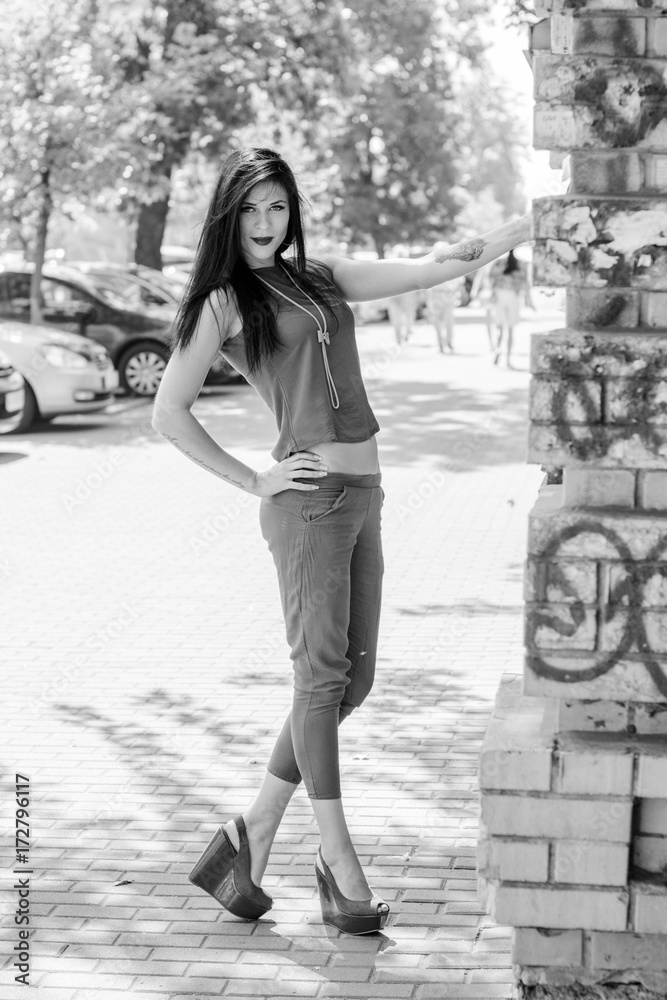 Beautiful stylish woman with long hair walk on the streets of Europe with good mood