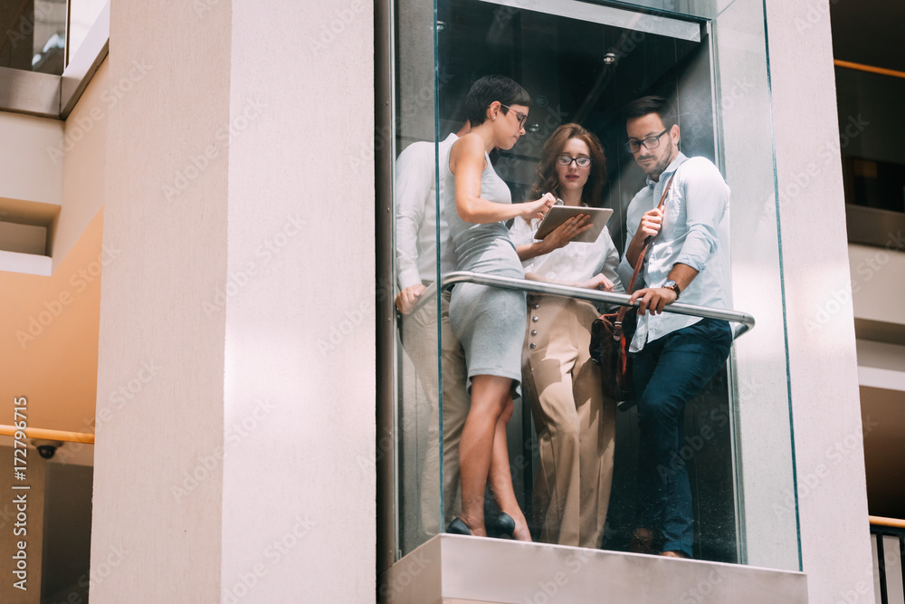 Picture of young businesspeople talking in elevator Picture of young businesspeople talking in elevator