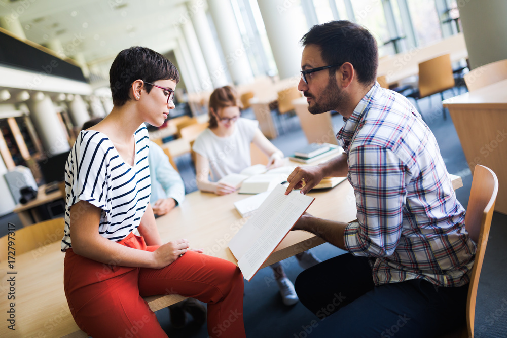 Young attractive students spending time in library Young attractive students spending time in library