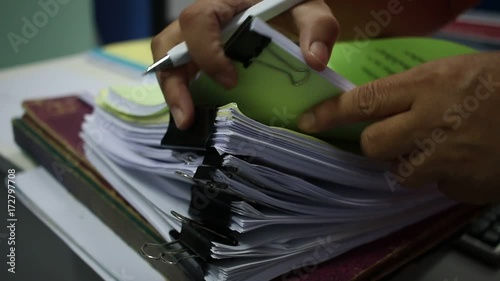 Officer Businessman searching data in Stacks of papers files on work desk in office, business report paper or piles of unfinished documents notation with clips on offices desk, Business concept