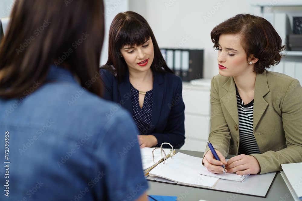 frauen im büro schauen gemeinsam auf unterlagen frauen im büro schauen gemeinsam auf unterlagen