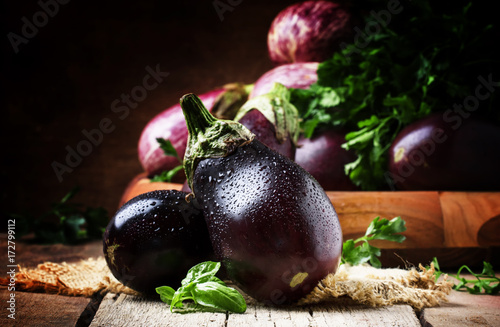 Quadro em tela Fresh aubergines on vintage wooden background, selective focus