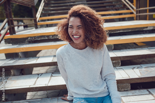Canvas Print Curly haired girl with freckles in blank grey sweatshirt on the street