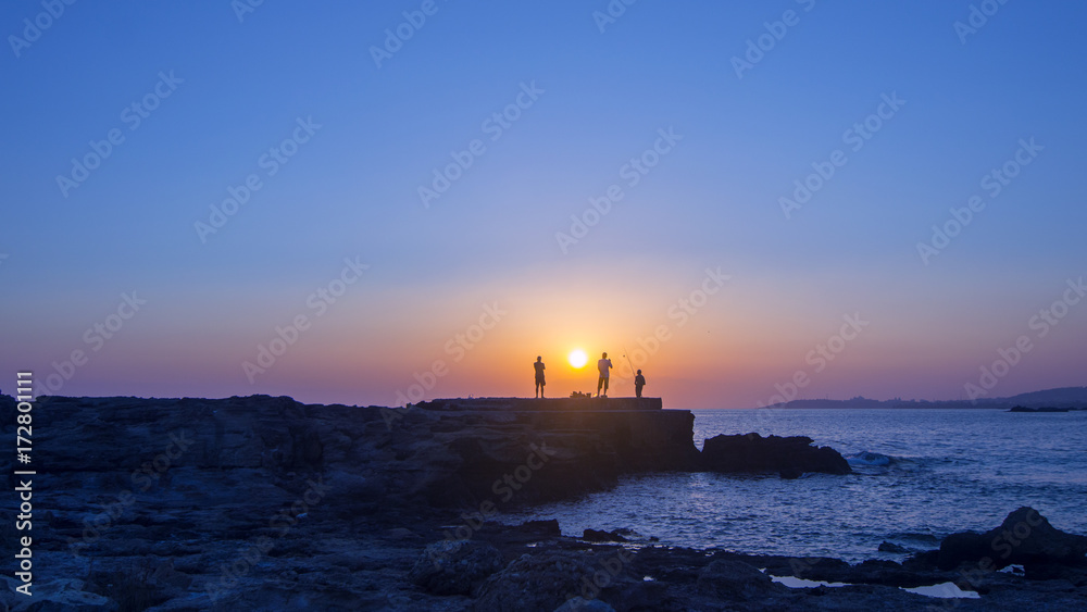  Landscape of Sunset fishing silhouettes of fishermen near the sea coast 