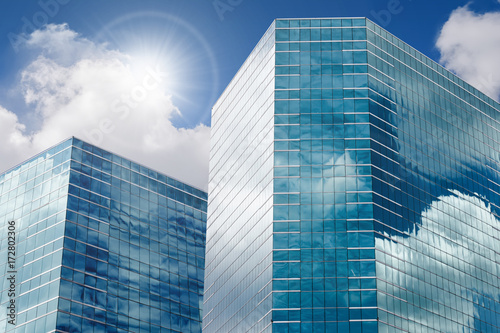 Blue sky and clouds reflecting in windows of modern office building