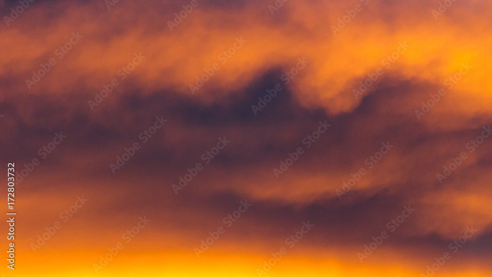Background texture of dramatic sunset sky with orange clouds after thunderstorm