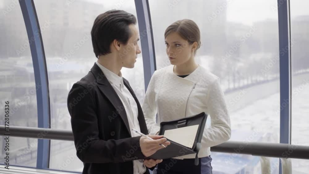 young business team stay opposite window in modern business centre and speak, men take document case and mark up in document young business team stay opposite window in modern business centre and speak, men take document case and mark up in document