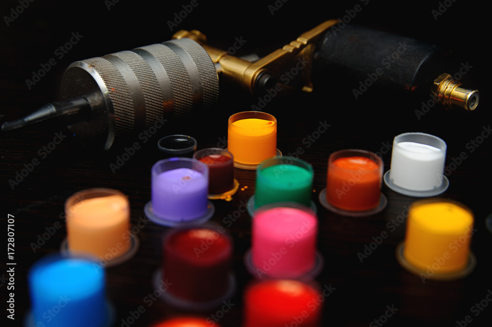 colored tattoo ink in the caps for tattoo ink on a gold background