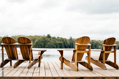 Slika na platnu Adirondack Chairs at the end of a pier