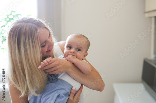blonde mom kiss and hug baby, real interior