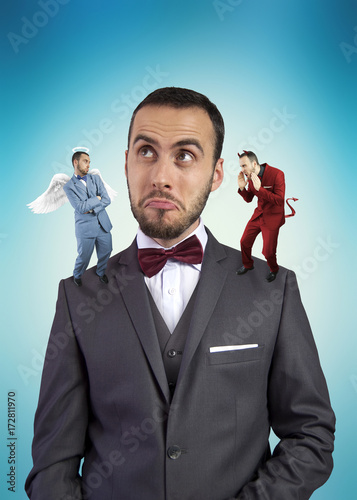 Businessman with angel and devil on his shoulders. photo