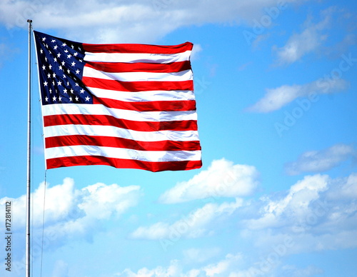 USA flag flying high in the sky outdoors.