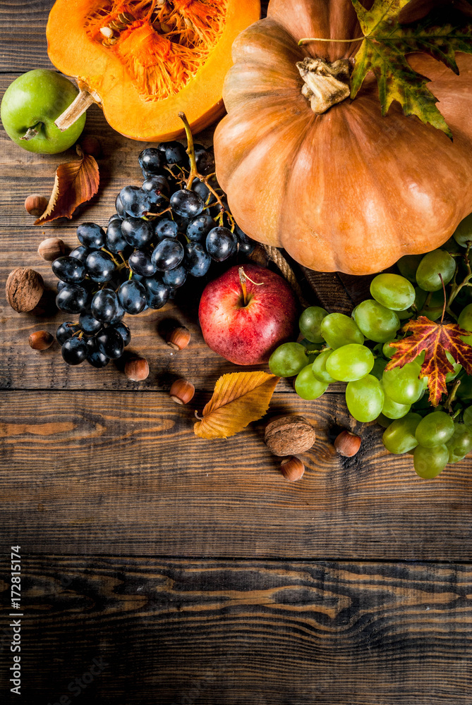 Autumn and thanksgiving harvest concept. Seasonal fall fruits and pumpkin on wooden table, copy space