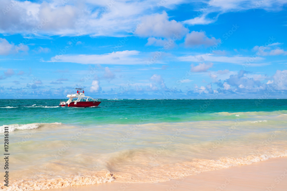 Coastal Caribbean landscape with red motorboat