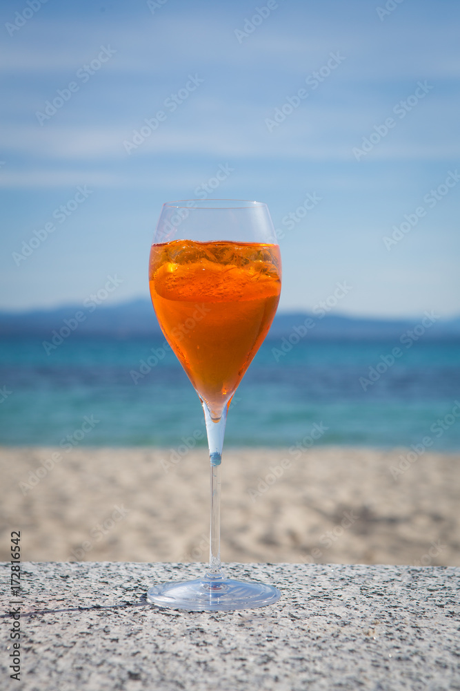 Obraz premium aperol spritz in the sun on a seaside terrace