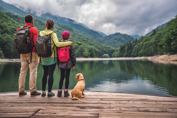 Family with dog standing on a pier