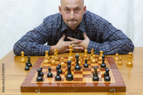 Man playing chess on light background. closeup of young man thinking over move