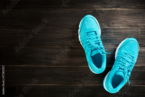 pair of blue sneakers on wooden background.