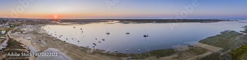 Sunrise aerial seascape, in Ria Formosa wetlands natural park, shot over Cavacos beach. Algarve.