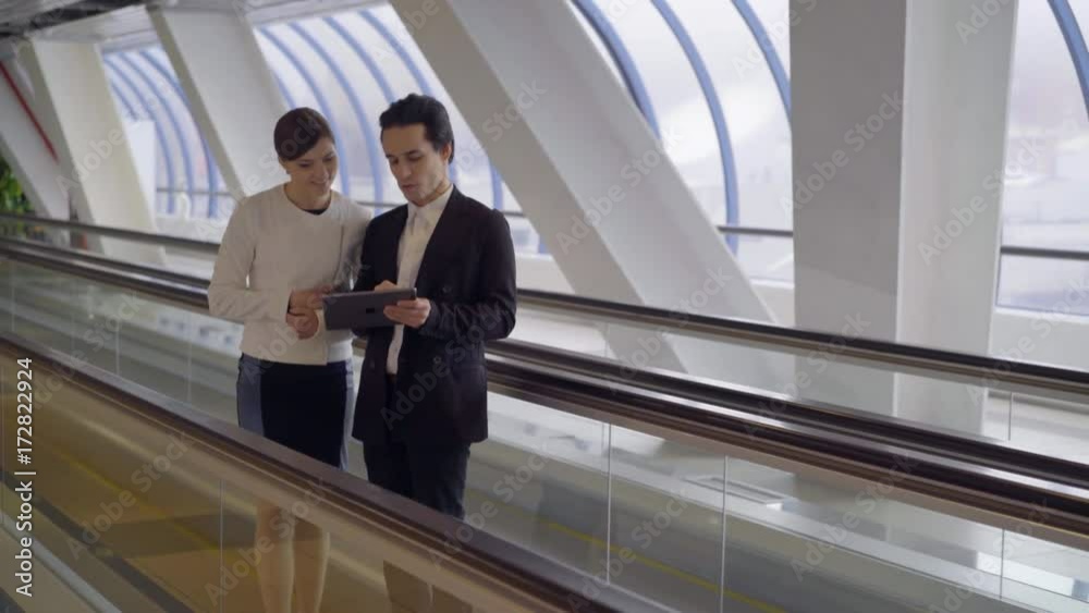 young business team stay on moving stairway in modern business centre and speak young business team stay on moving stairway in modern business centre and speak