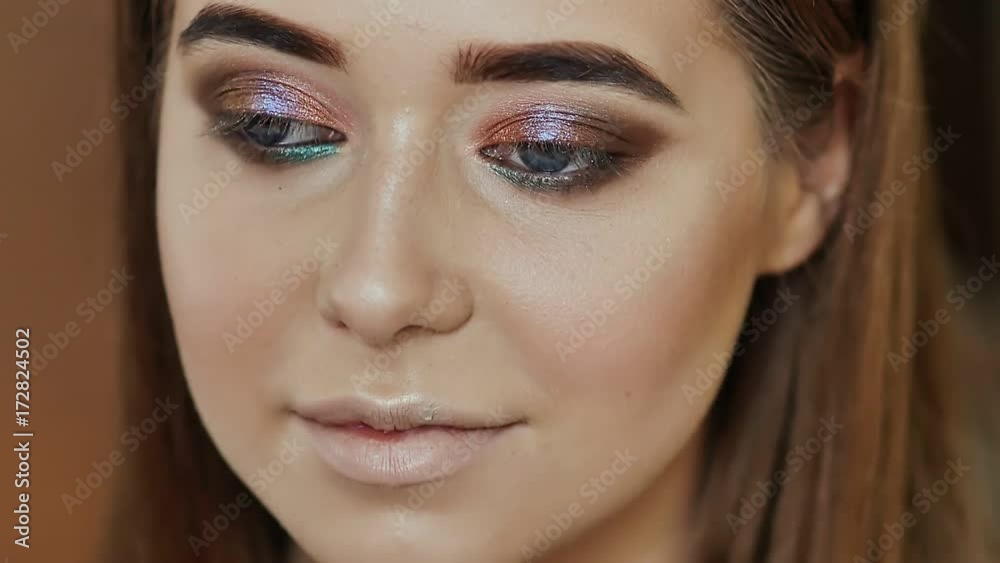 Girl makeup artist paints the eyes of the girl model. Stroke for the lower eyelids. Girl makeup artist paints the eyes of the girl model. Stroke for the lower eyelids.