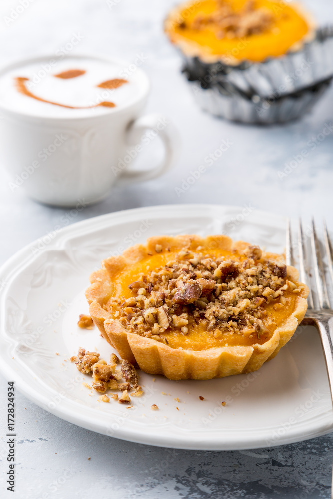 Pumpkin mini pie, tartlet made for Thanksgiving day on gray stone background. Healthy autunm food concept.