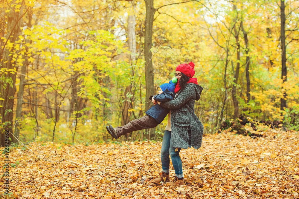 Happy mother and son walking and playing fun together in autumn park. Happy mother and son walking and playing fun together in autumn park.