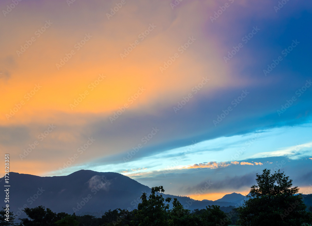 Colorful Sky and Clouds drifting over the forest mountain in evening time