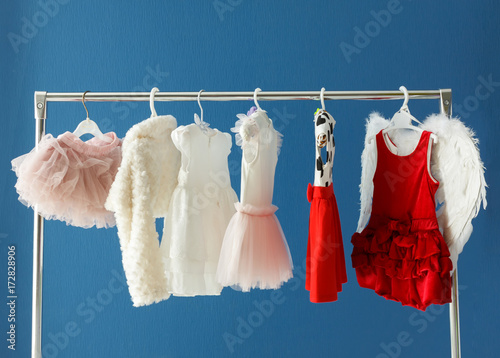 Clothing for a little girl on a clothes rack in a wardrobe photo