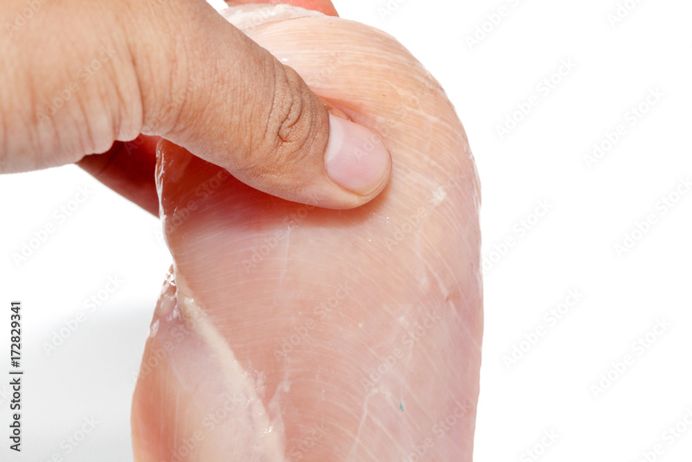Fototapeta premium hand holding raw chicken breast on white background