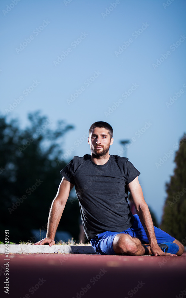 Fototapeta premium The young guy rests on the running track