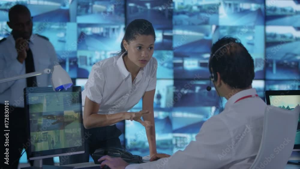 Security team watching multiple CCTV video screens in system control room Security team watching multiple CCTV video screens in system control room