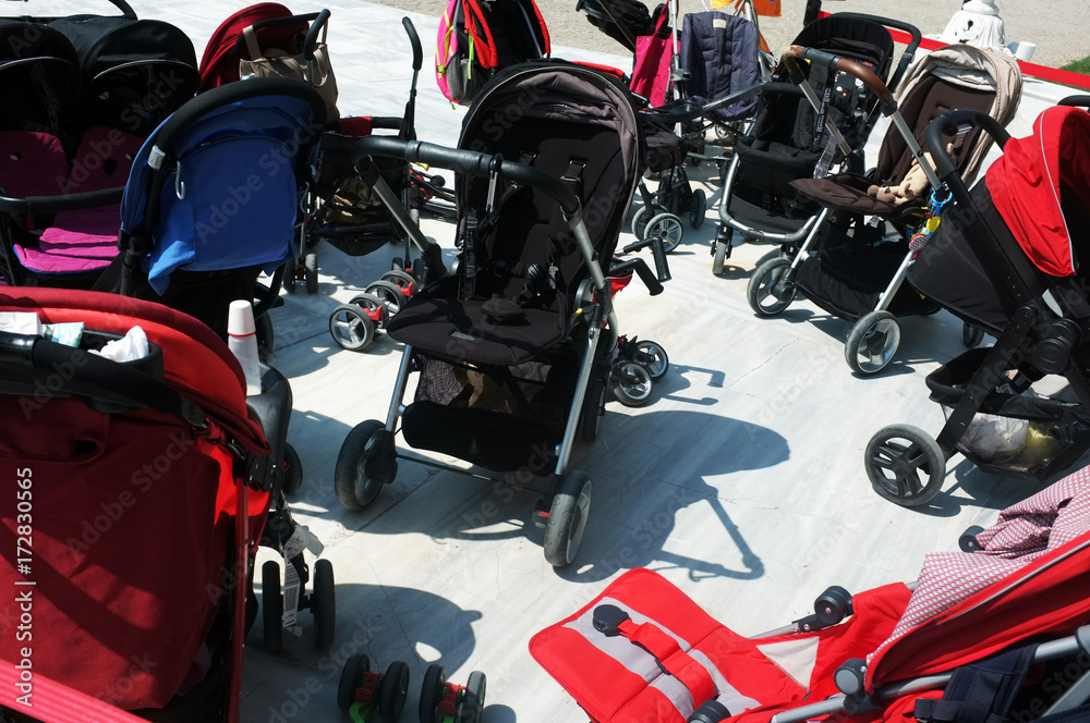 Baby buggies parked outside next to each other Baby buggies parked outside next to each other