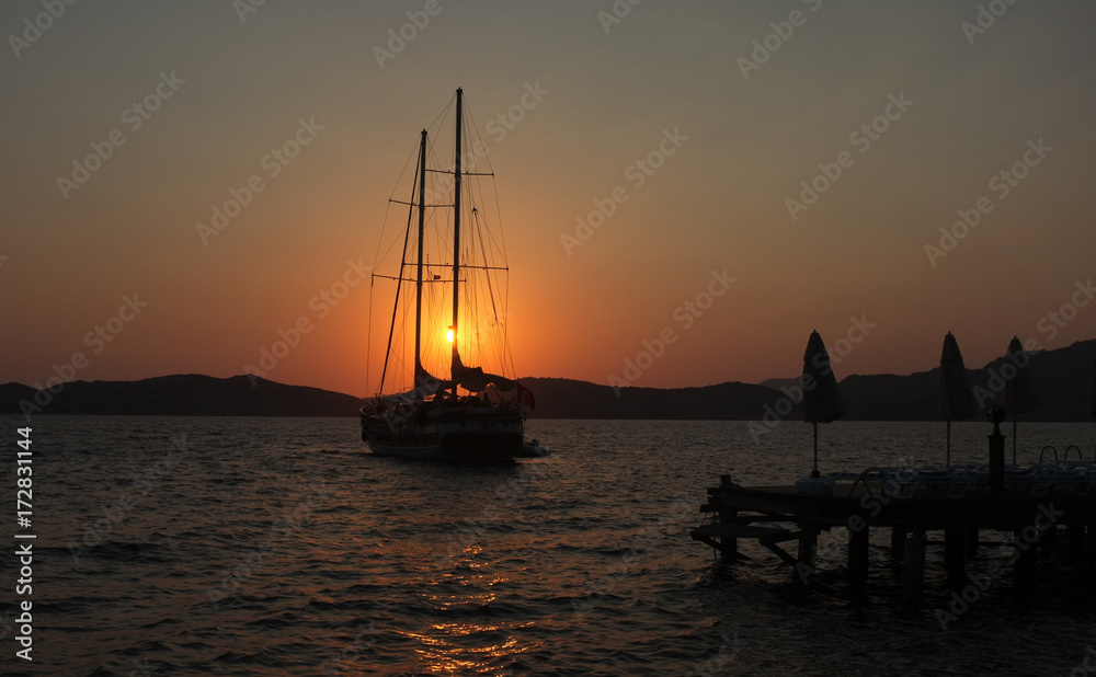 Yacht and jetty silhouettes at dawn in Marmaris, Turkey