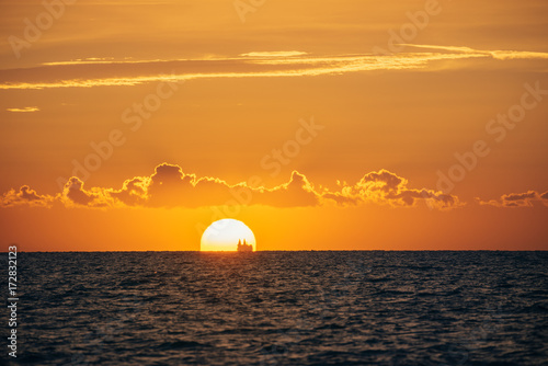 Albania. Golem. Sunset on the Adriatic Sea with the silhouette of the ship on the horizon
