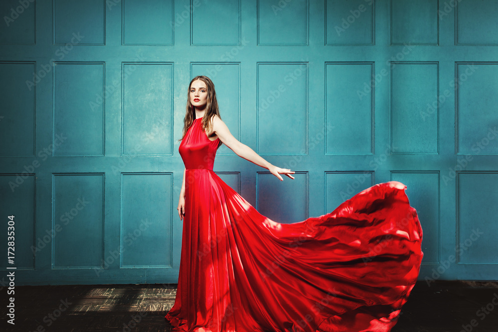 Stylish Woman in Red Dress. Glamourus Beautiful Fashion Model wearing Evening  Gown on Blue Background Stock Photo | Adobe Stock