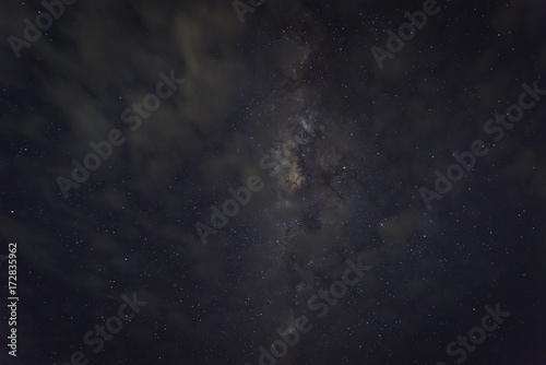 Milky Way Under the Cloud Over Tanjung Layar Beach in Sawarna, Banten, Indonesia. Long exposure and High ISO Photograph, with Visible Grain and Noise, Blur, and Soft Focus.