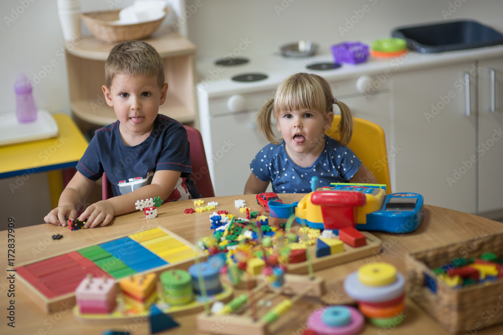 Fototapeta premium Caucasian brother and sister is playing with toys