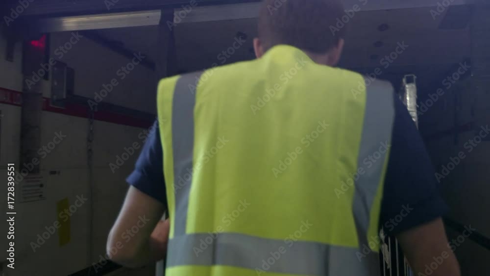 Man loads roll cage into back of truck, back view shot on R3D Man loads roll cage into back of truck, back view shot on R3D