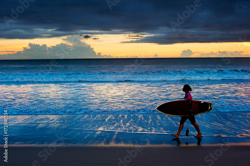 Woman surfer at sunset. Bali