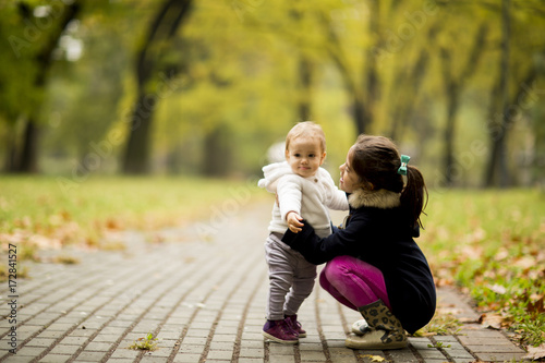 Two little girl's sisters in the autumn park