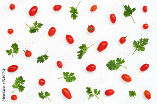 Pattern of red mini tomatoes and salad greens, parsley on white background, healthy food.