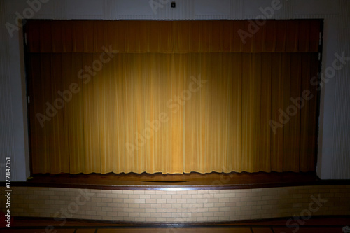 Drawn curtains with spotlight on school stage
