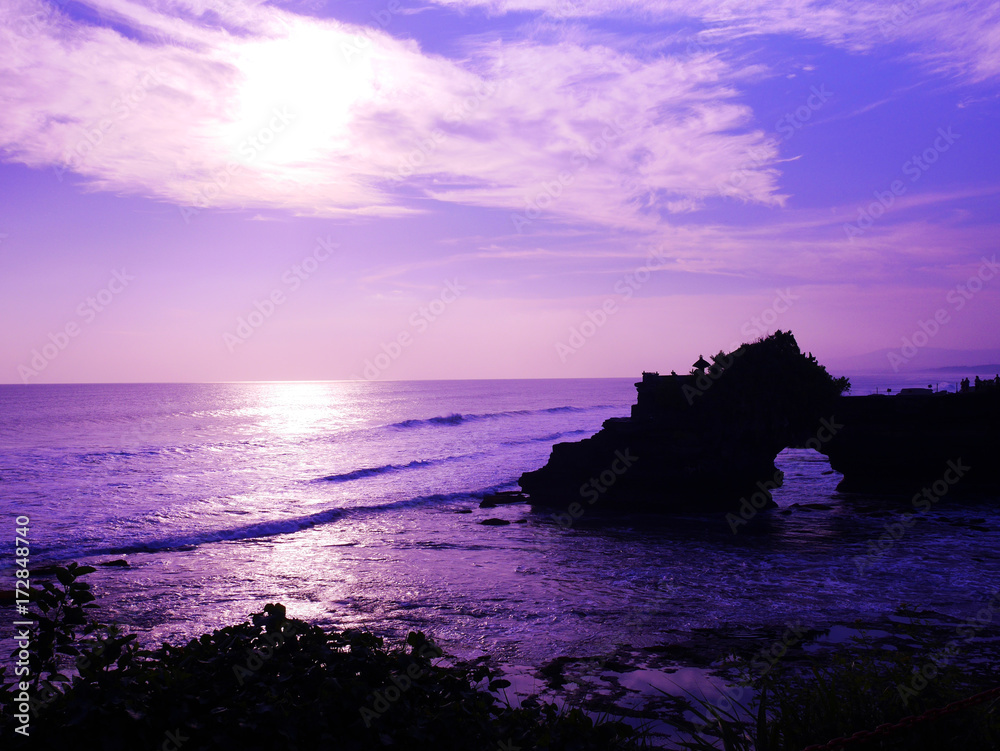 Colorful silhouette sunset at Tanah Lot in Bali, Indonesia in purple tone for background