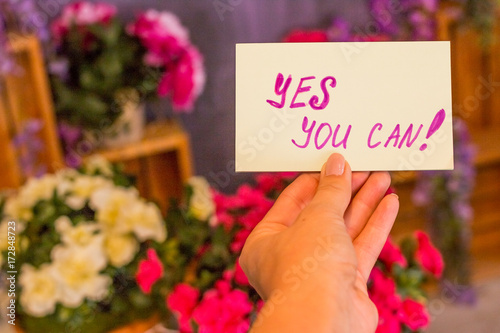 Business woman holding poster yes, you can,  text on it. Positive attitude & encouragement . Make it possible. Motivational concept.Toned image